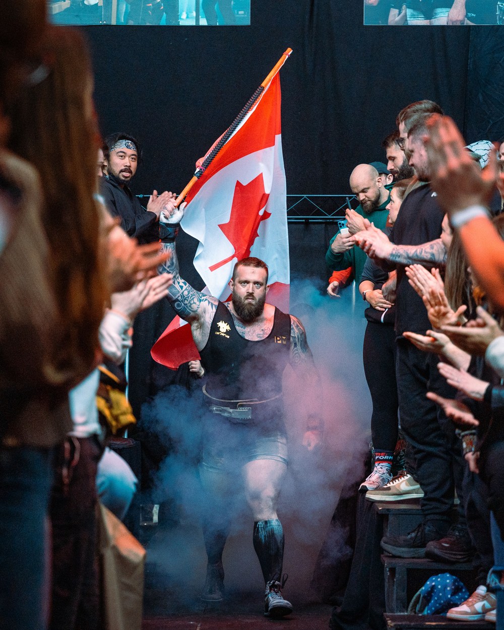 Justin Zottl carrying the Canadian flag at a powerlifting meet